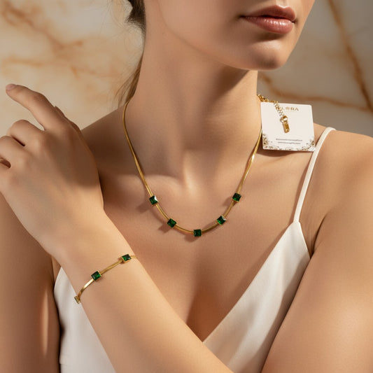 Woman wearing Emerald Whisper Serpentine Set – Gold-Plated Green Emerald Stone Embedded Snake Necklace & Snake Bracelet Set on a neutral background