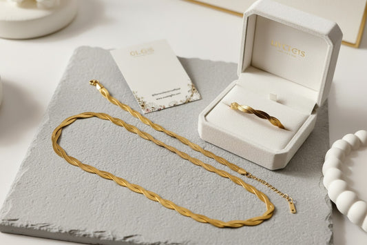Twisted Double layered Snake Necklace and snake bracelet on a gray surface with an open jewelry box in the background