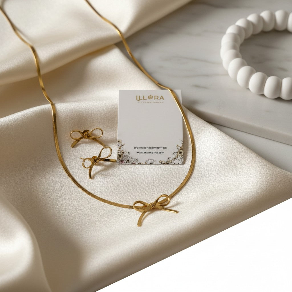 K-Glow Ribbon Duo Gold Plated Anti-Tarnish Jewellery Set for Women - Bow Necklace & Earrings on a beige fabric background