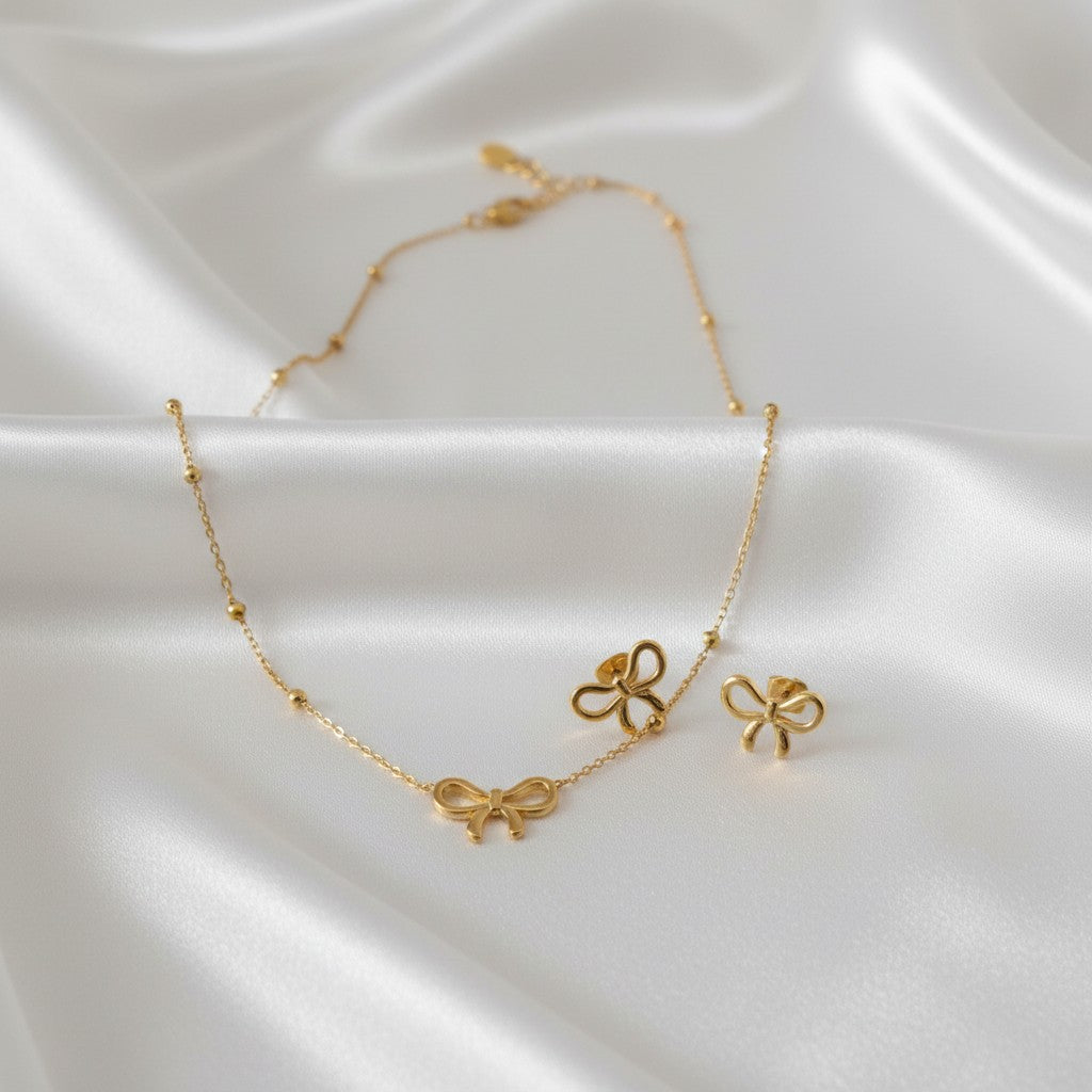 Anti-tarnish 18k Gold-plated Bow Chain Pendant, Bow Earrings & Bow Ring Set on a satin surface