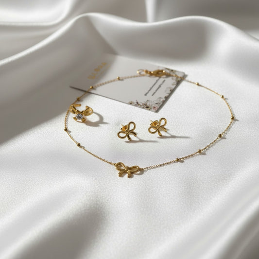 Sweet Bow Love Set – Anti-tarnish 18k Gold-plated Bow Chain Pendant, Bow Earrings & Bow Ring on a white fabric background