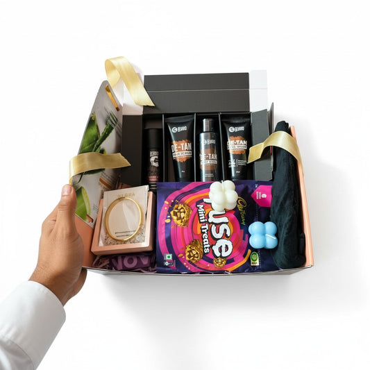 Hand holding Gift Hamper box with grooming and self-care products, anti-tarnish jewellery and sweet treats on a white background