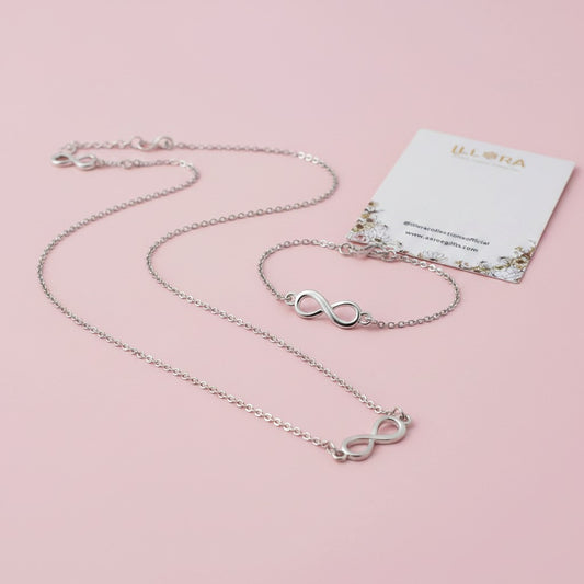 Eternal Infinity Duo – Silver-plated Infinity Chain Pendant & Infinity Bracelet against a pink background