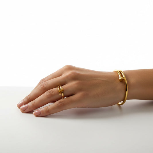 Hand wearing Bold Nail Statement Duo – Anti-tarnish 18k Gold-plated Nail Bracelet & Nail Ring Set on a white background