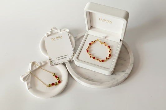 Scarlet Olive Tulip Gold Plated Anti-Tarnish Jewellery Set for Women containing Red & Olive Green Tulip Necklace & Tulip Bracelet on a marble surface