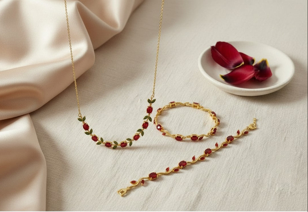 Scarlet Olive Tulip Gold Plated Anti-Tarnish Jewellery Set for Women on a beige fabric background with a plate of red flowers.