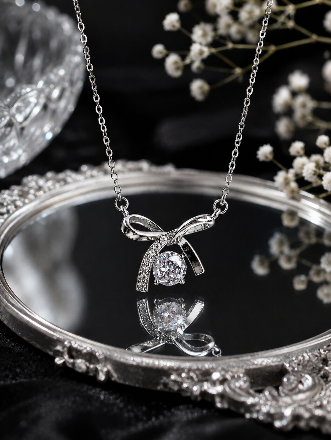 Aethel Silver Plated Twisted Infinity Necklace for Women, displayed on an ornate silver tray with a black reflective surface