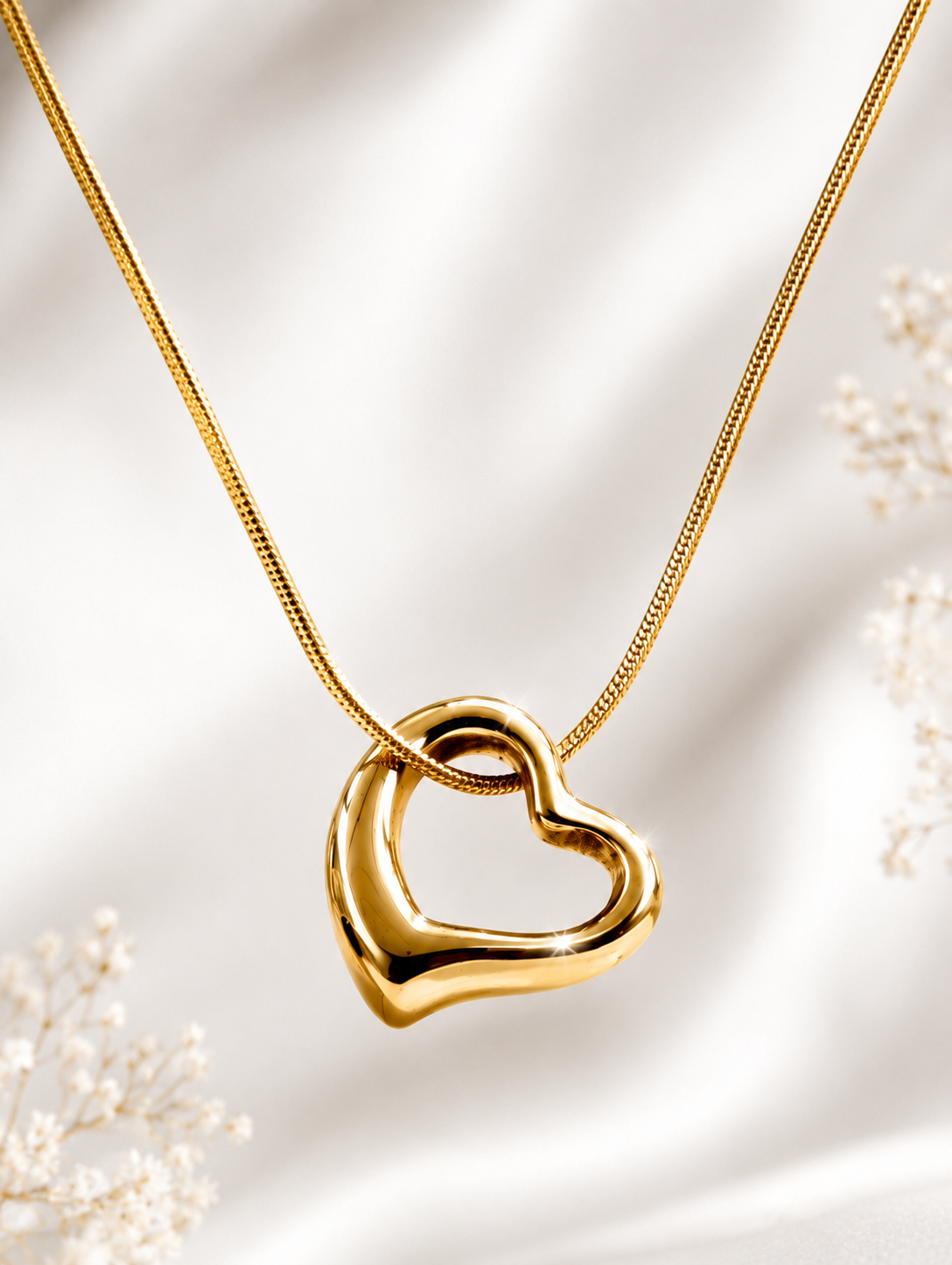 Aurelia Gold Plated Anti Tarnish Tilted Heart Necklace displayed against a soft white satin fabric backdrop