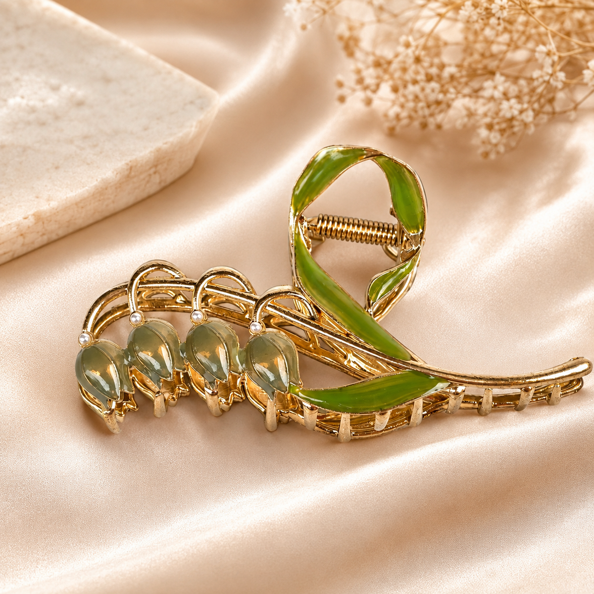 A claw-style tulip hair clip displayed on a beige satin fabric