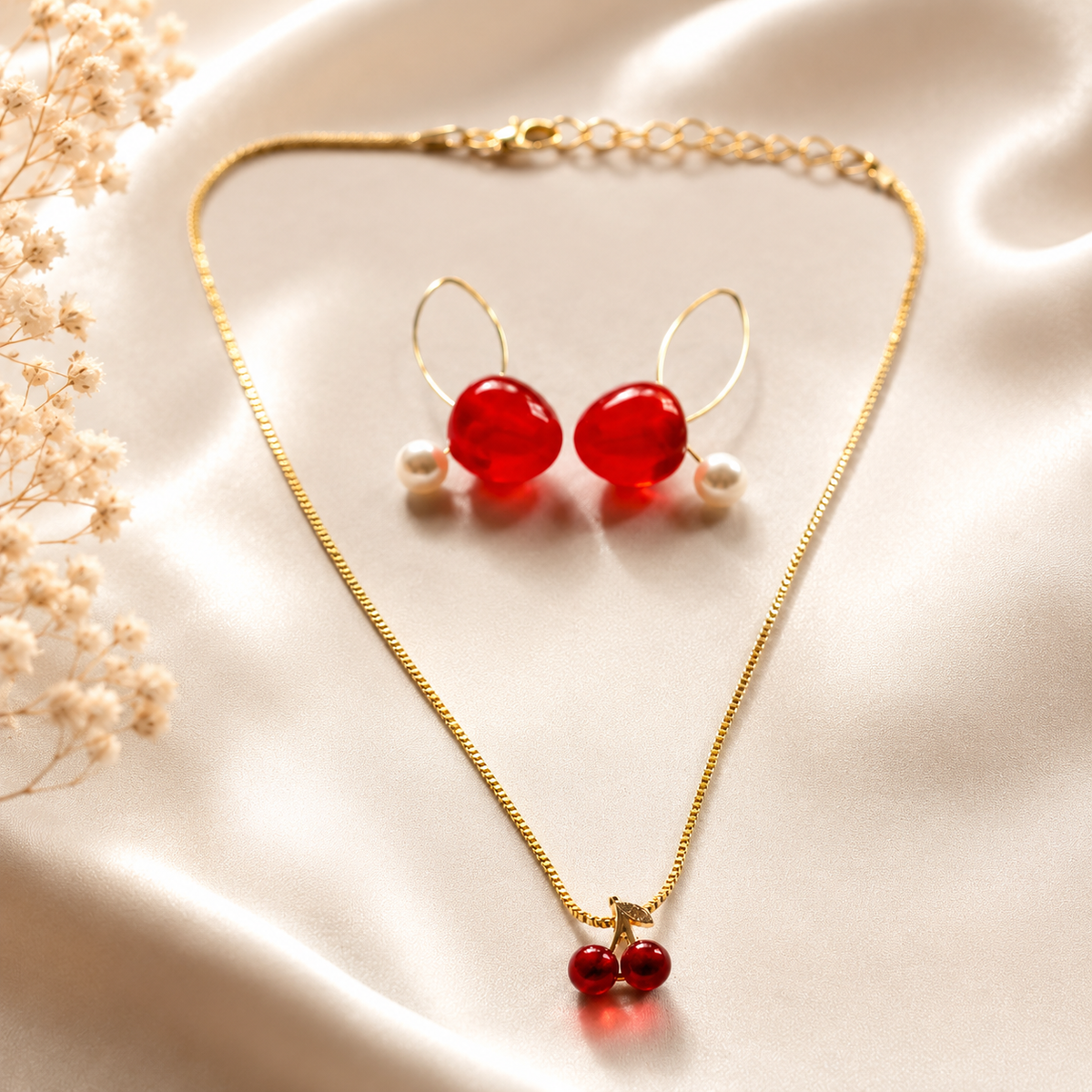 Gold-toned jewelry set featuring a delicate cherry necklace and matching cherry earrings