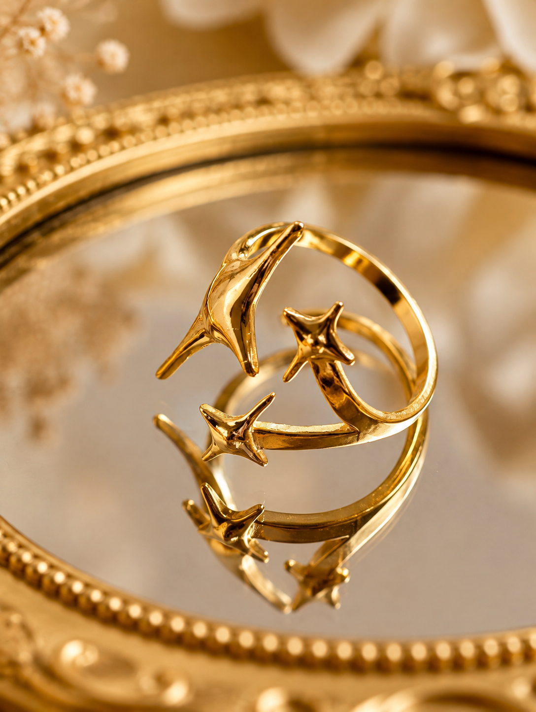 Stellina Gold Plated Anti Tarnish Statement Star Ring, displayed on a reflective gold mirror with a decorative gold frame.