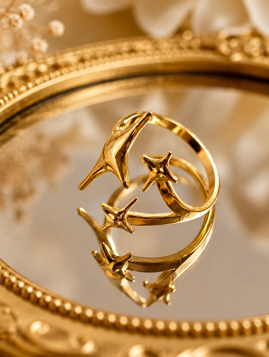 Stellina Gold Plated Anti Tarnish Statement Star Ring, displayed on a reflective gold mirror with a decorative gold frame.