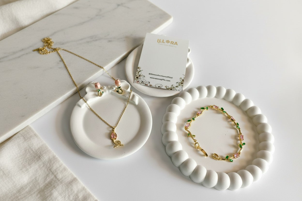 Tulipa Petal Muse Gold Plated Anti-Tarnish Jewellery Set for Women with Pink & Green Tulip Pendent Necklace, Bracelet & Earrings on a marble surface with a card.